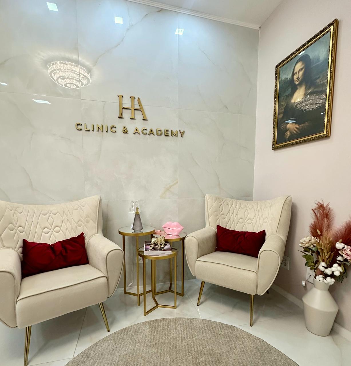 Recepção da HA Estética Avançada com poltronas claras e painel com o monograma HA